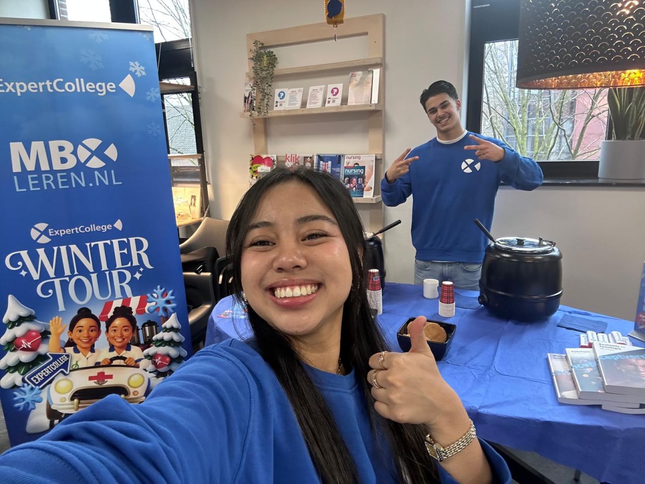 Selfie van het ExpertCollege-team bij de Winter Tour-banner